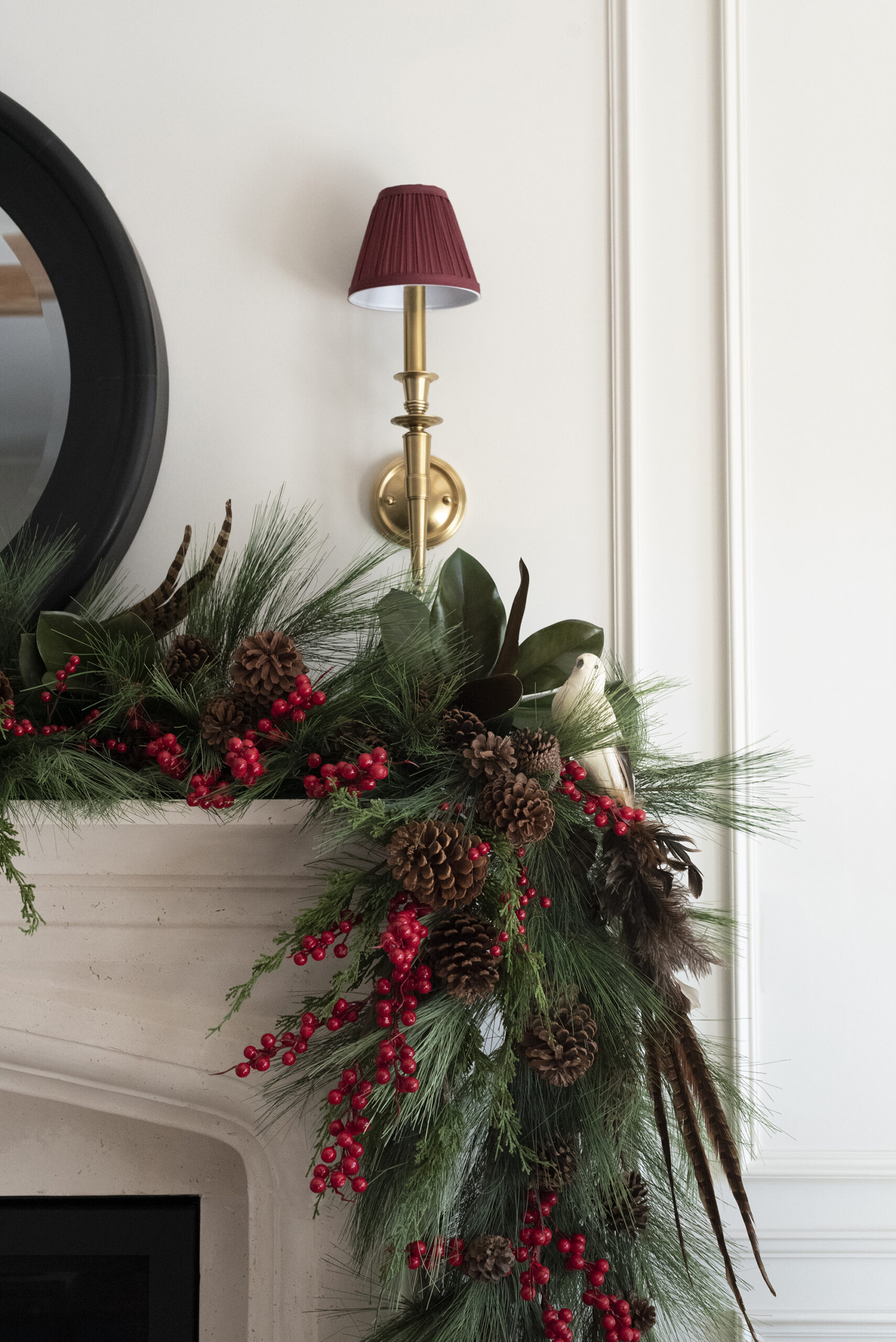 Red Lampshade on Brass Sconce with Pine Garland Mantel