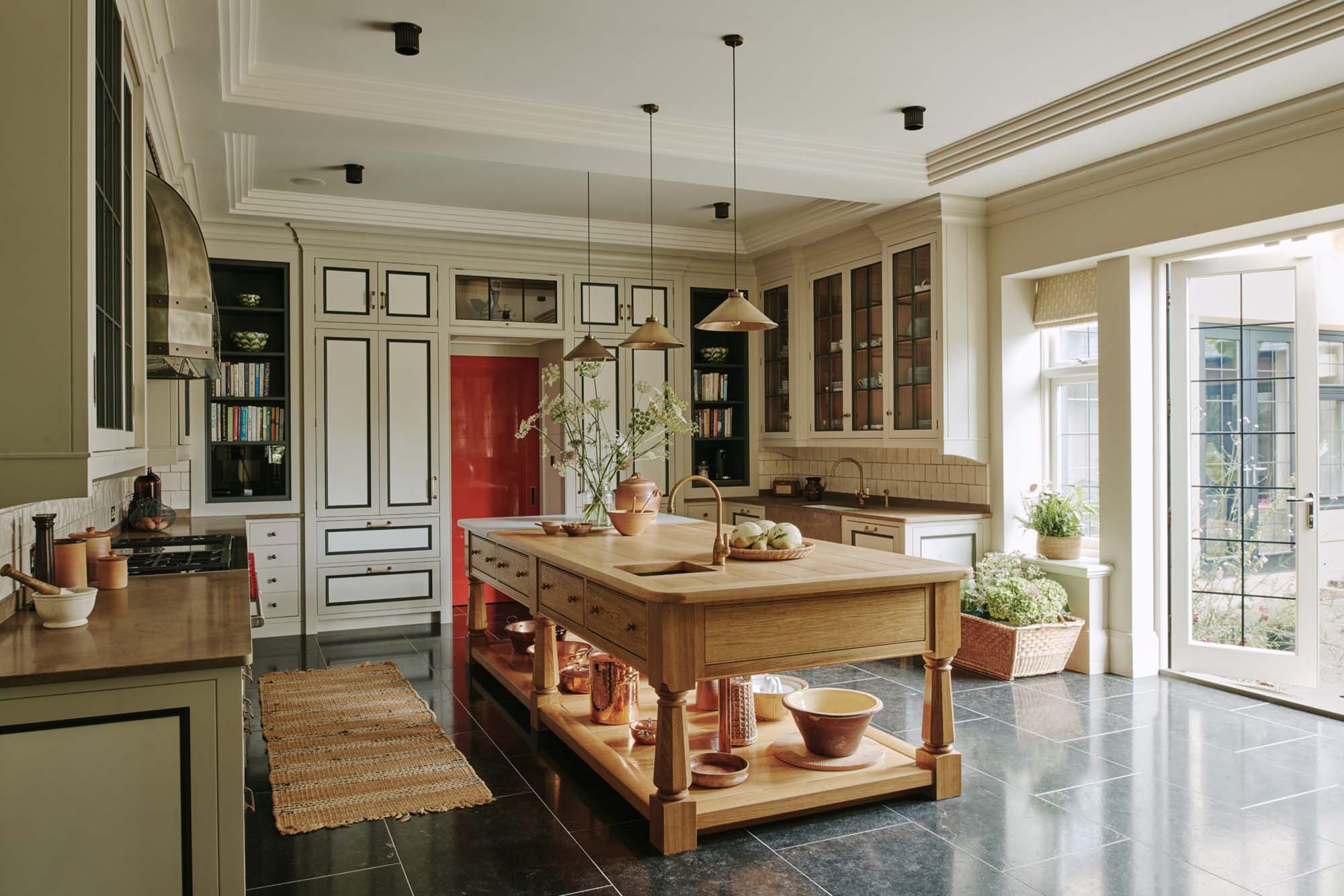 Art-deco-inspired-kitchen-with-wood-island-black-tile-floor-and-brass-fixtures