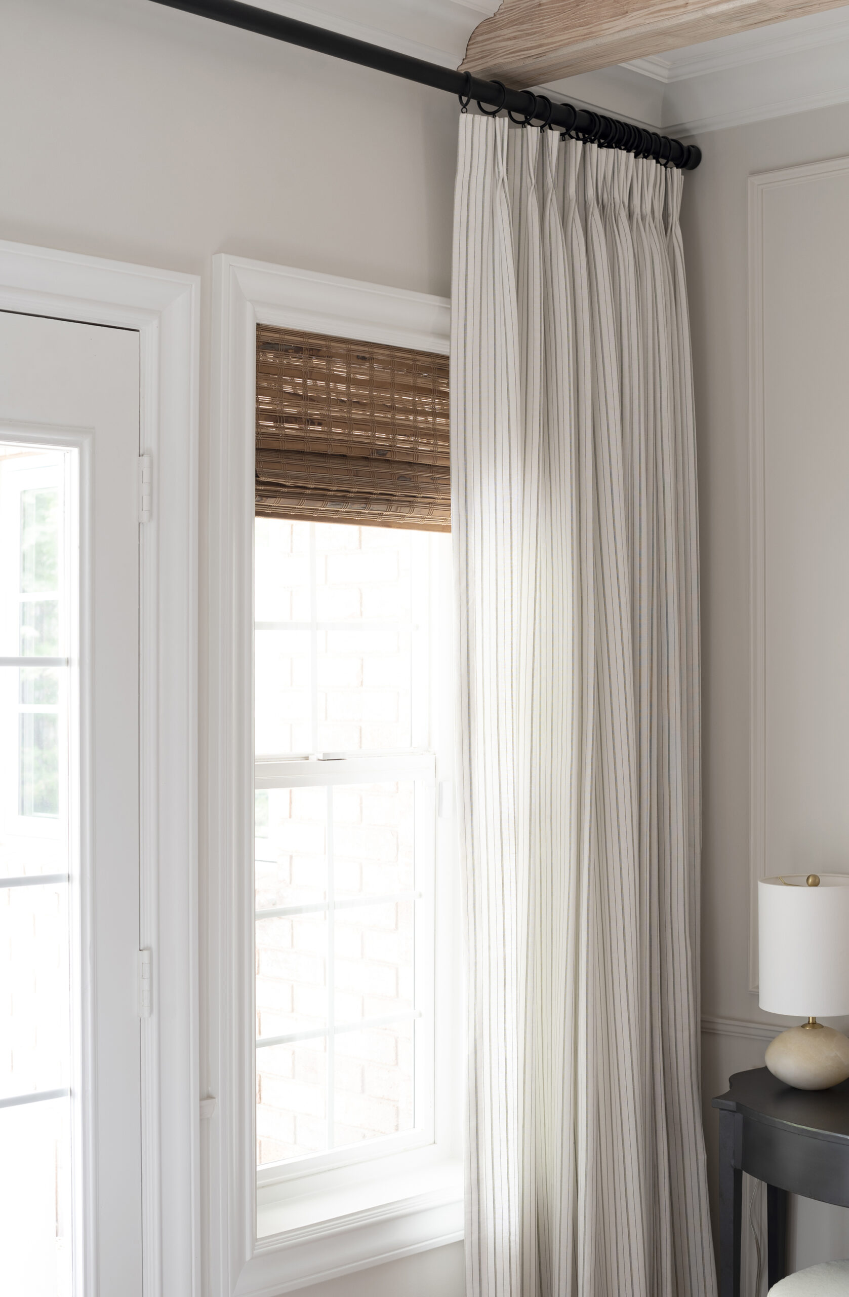Pleated Striped Curtain Layered with Woven Wood Roman Shade Window Treatment