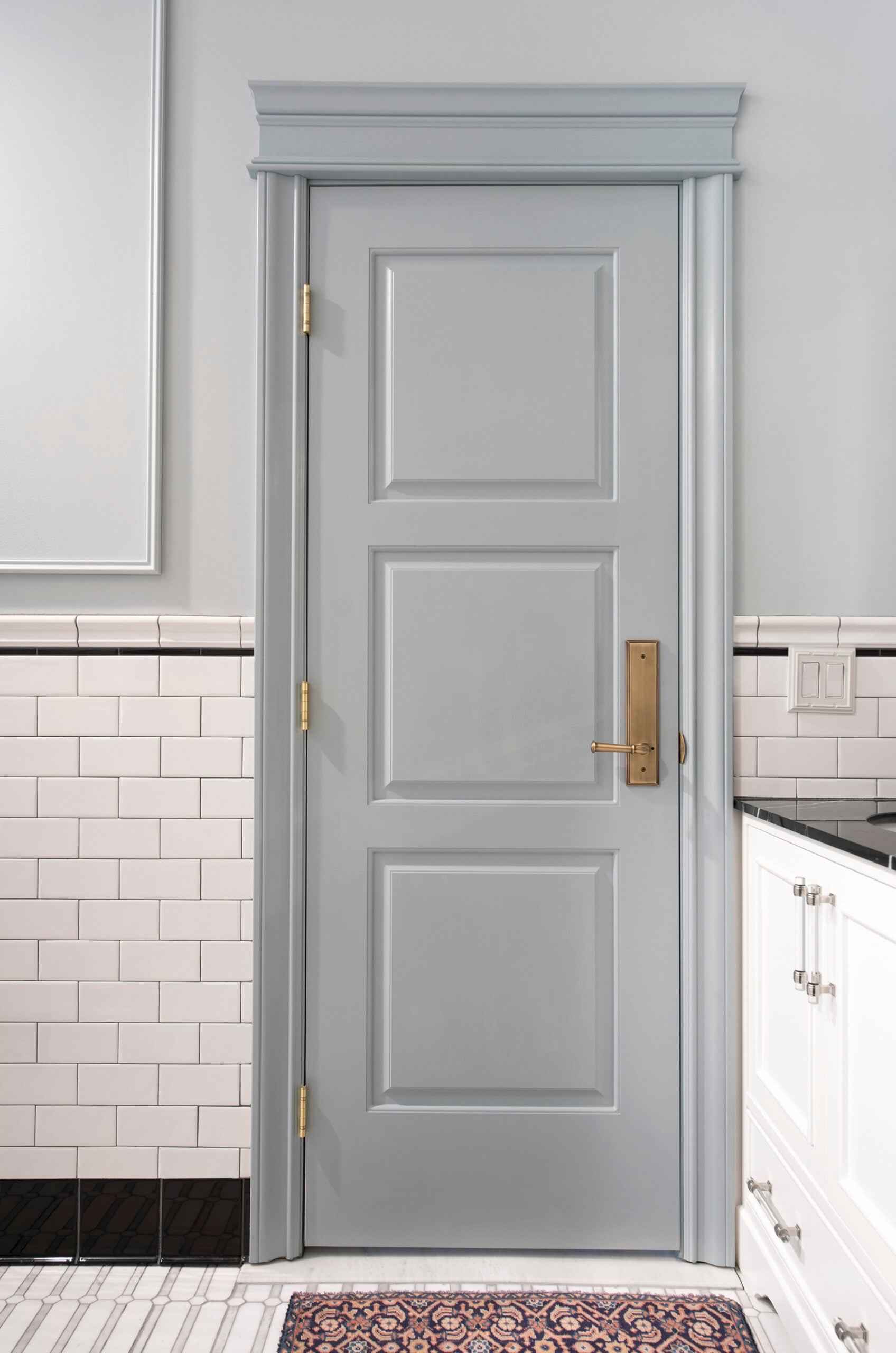 Blue Door with Brass Hardware in Bathroom with White Tile