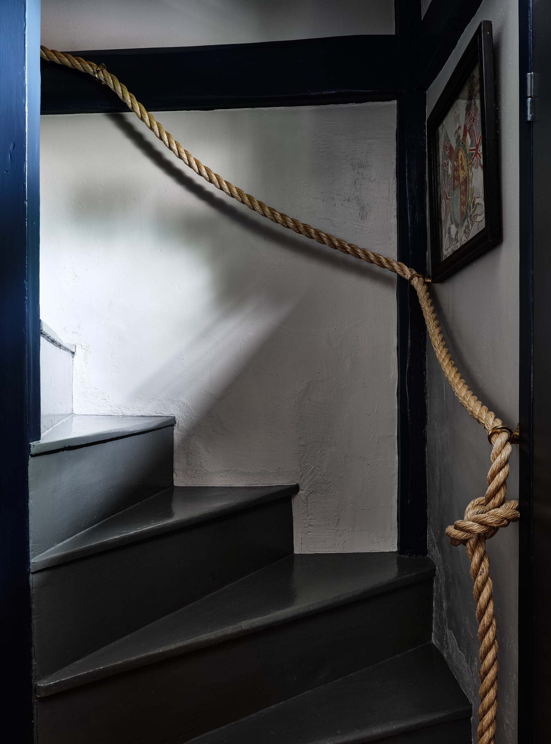 KristinPaton-Nantucket Dark Moody Staircase with Rope Handrail from bottom showing art