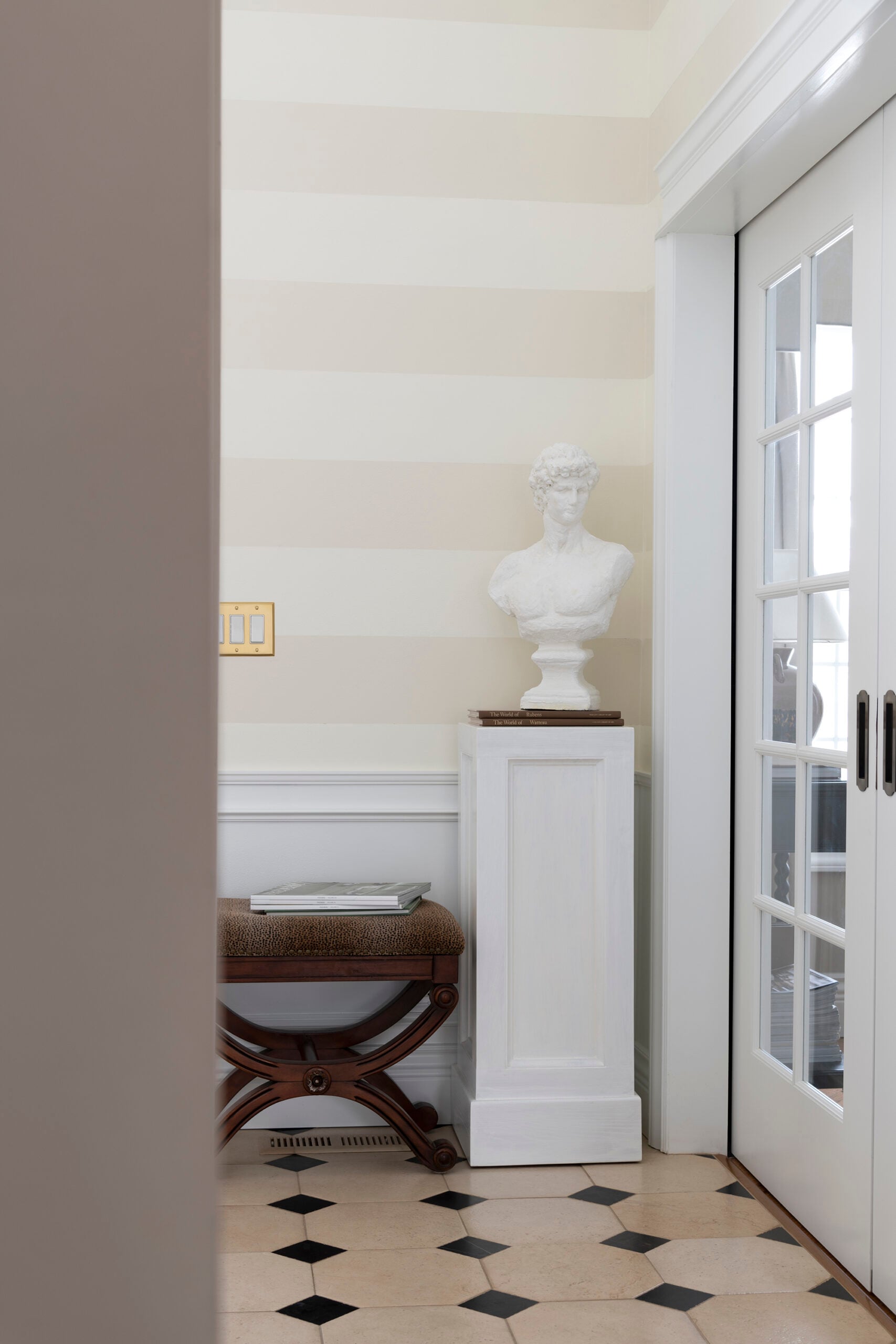 Millwork Details in Striped Foyer with Limestone Cabochon Floor Tile