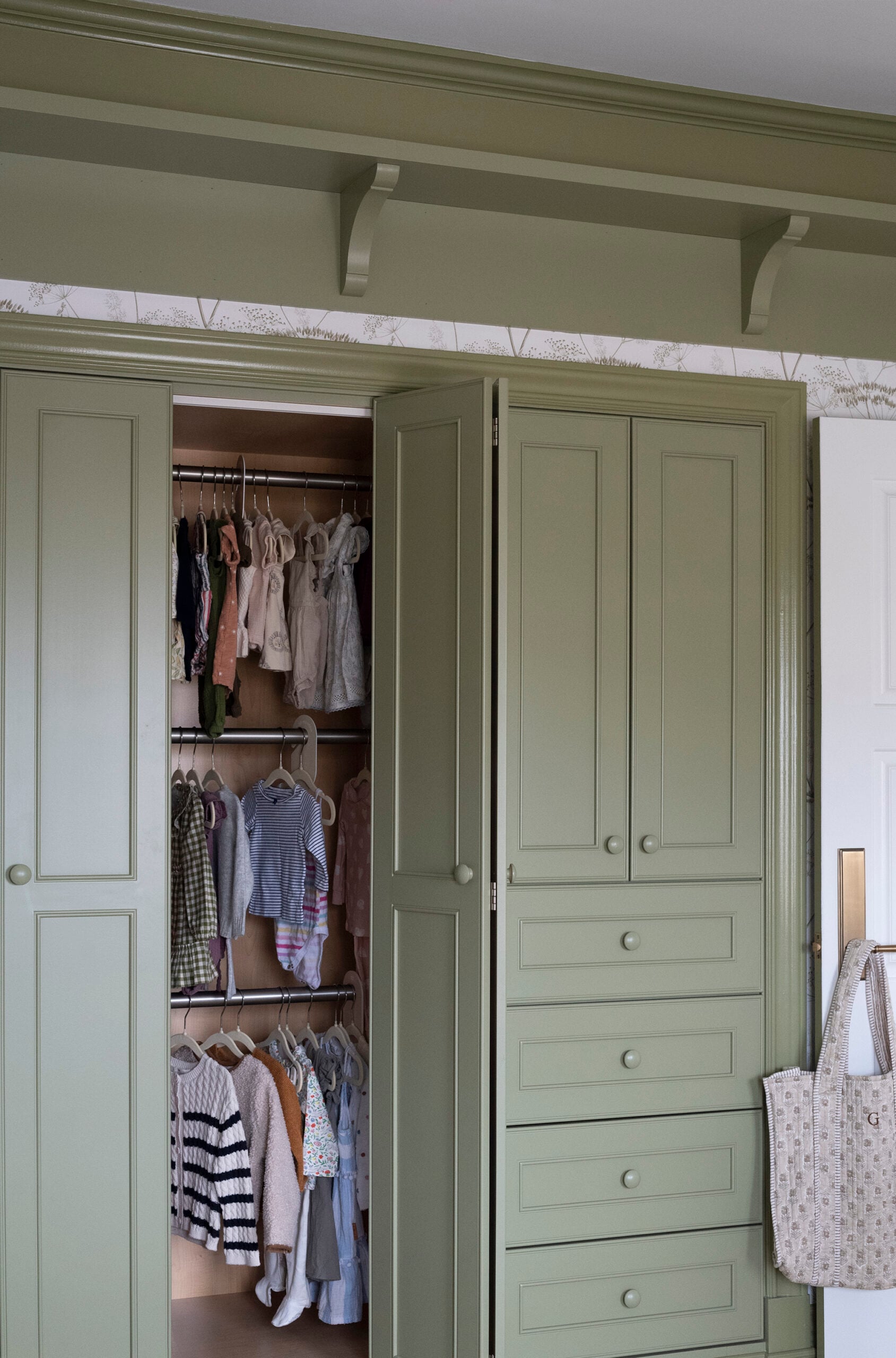Built-In Green Closet in Girl Nursery with Three Clothing Racks