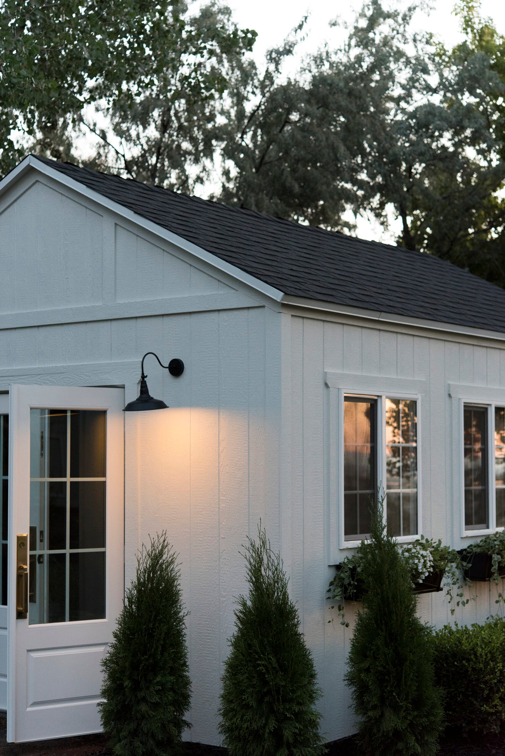 Cute Garden Shed with Sconces and Window Planters
