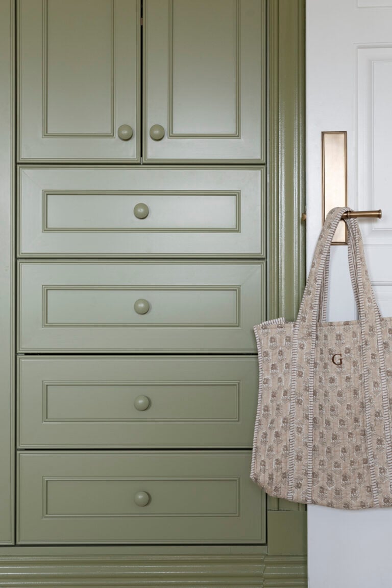 Green Built-In Cabinetry Closet in Girls Nursery with Patterned Tote on Brass Doorknob