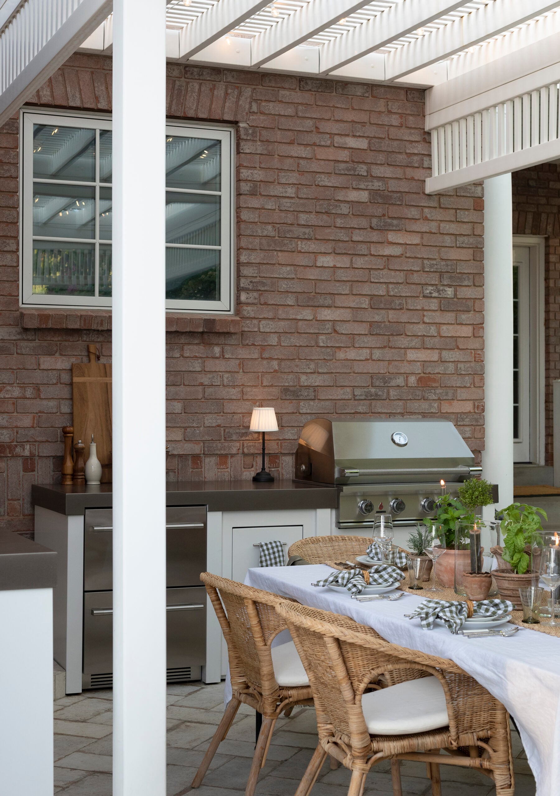 Outdoor Dining Area Under Pergola with Outdoor Kitchen and Grill
