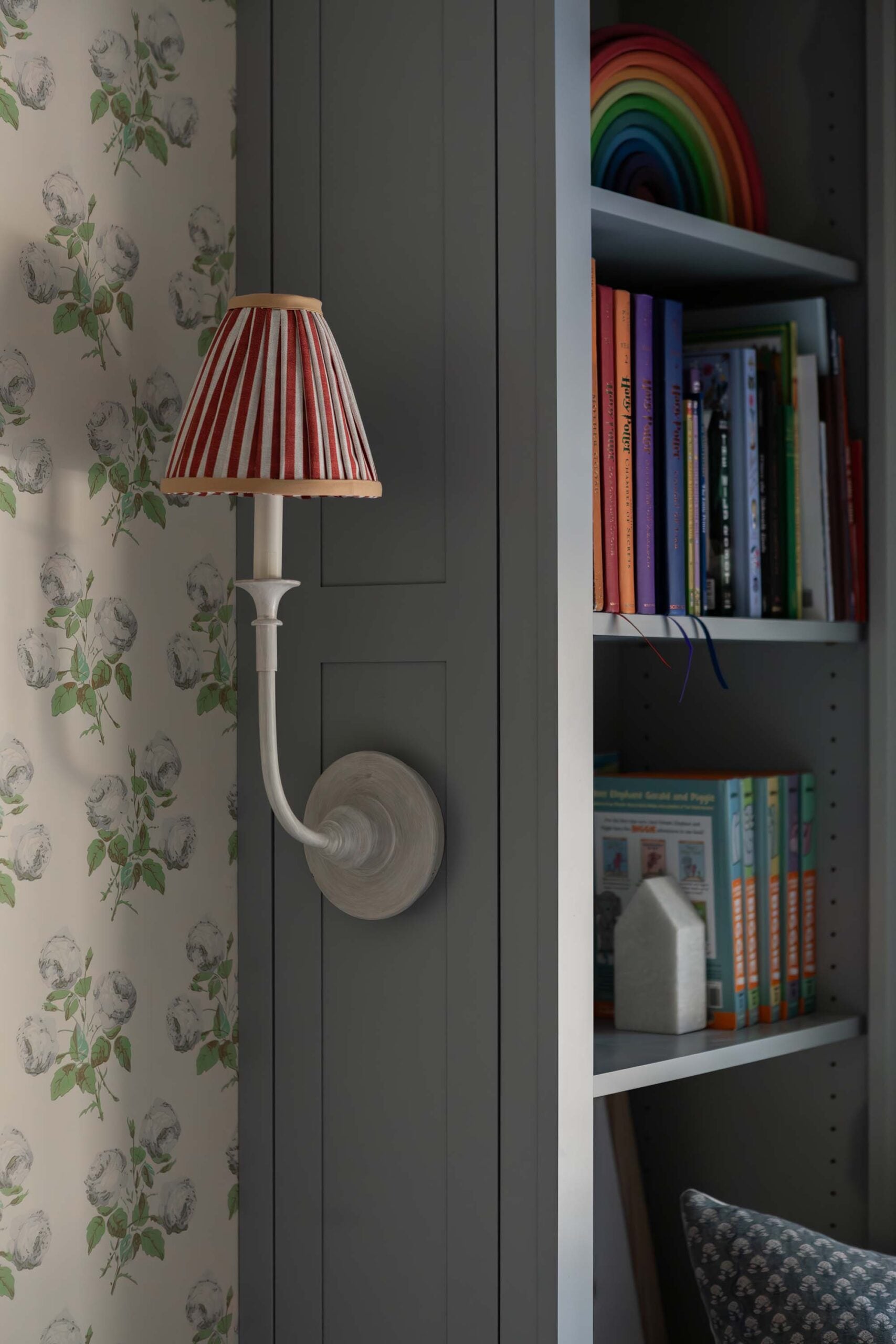 Oho Interiors-Carriage House-Built In Book Shelf with White Sconce Rainbow Decor and Books