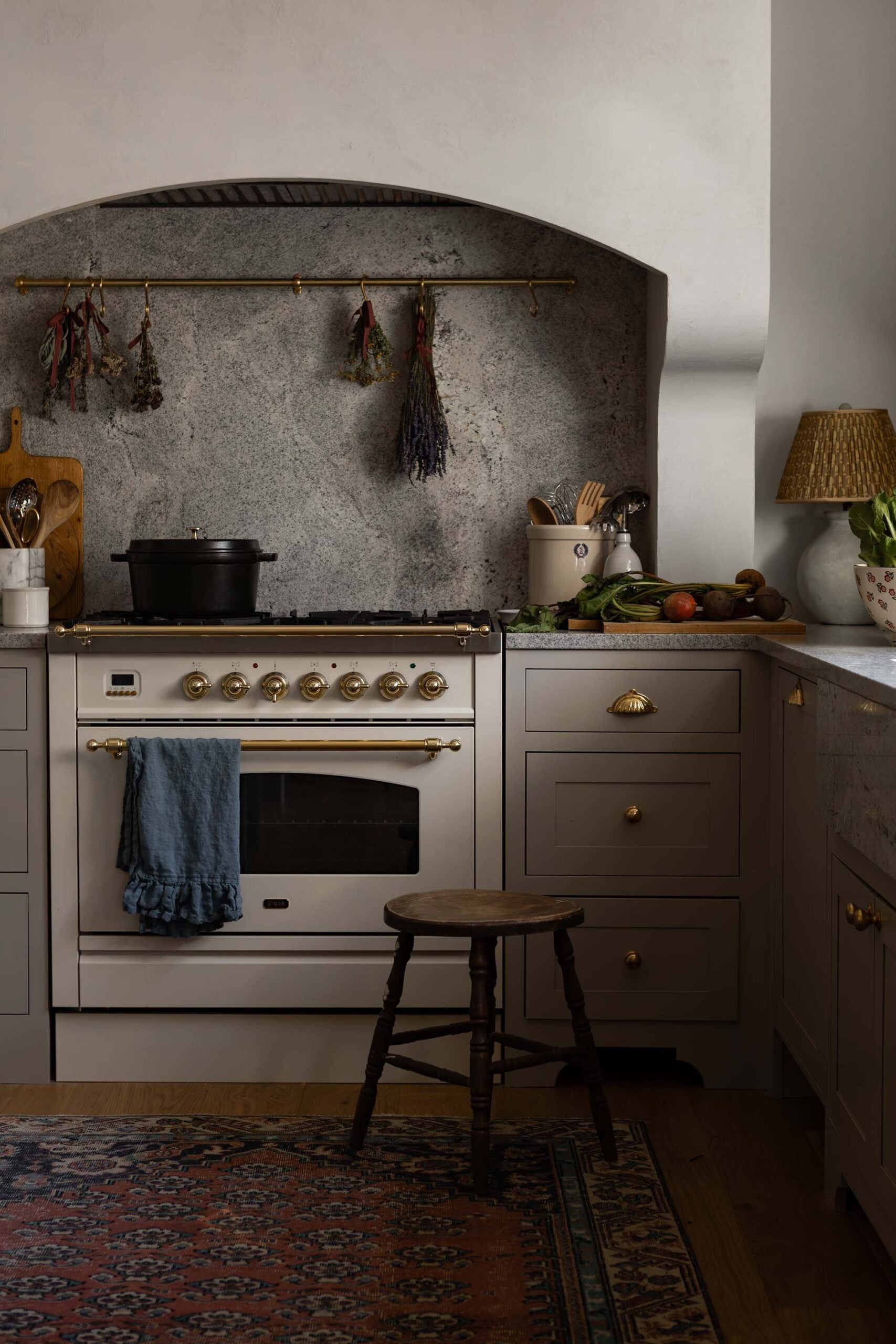 Oho Interiors-Carriage House-White Gas Range with Arch hood matching stone coutertop and solid backsplash