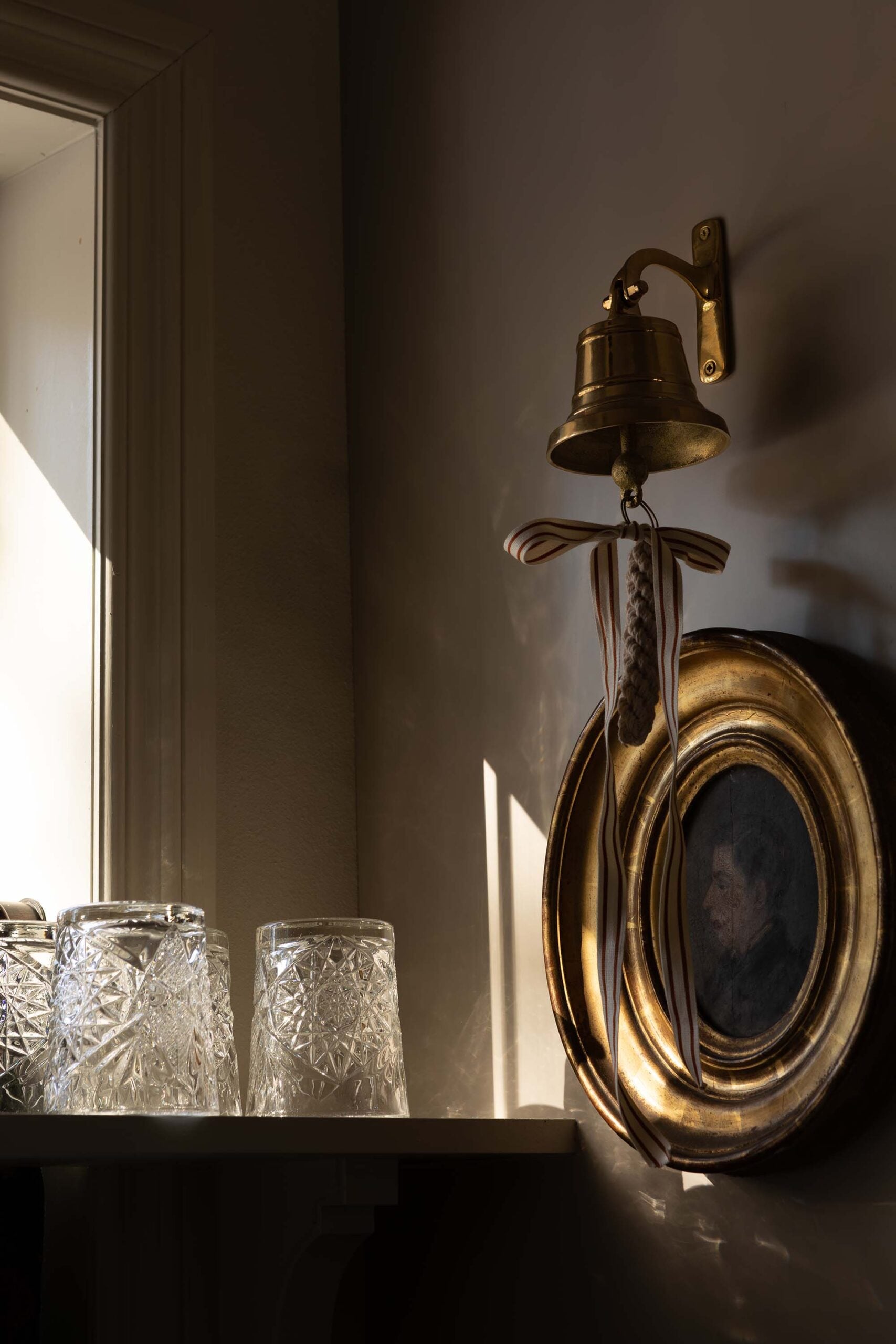 Oho Interiors-Carriage House-dinner bell with artwork and open shelf for water glasses