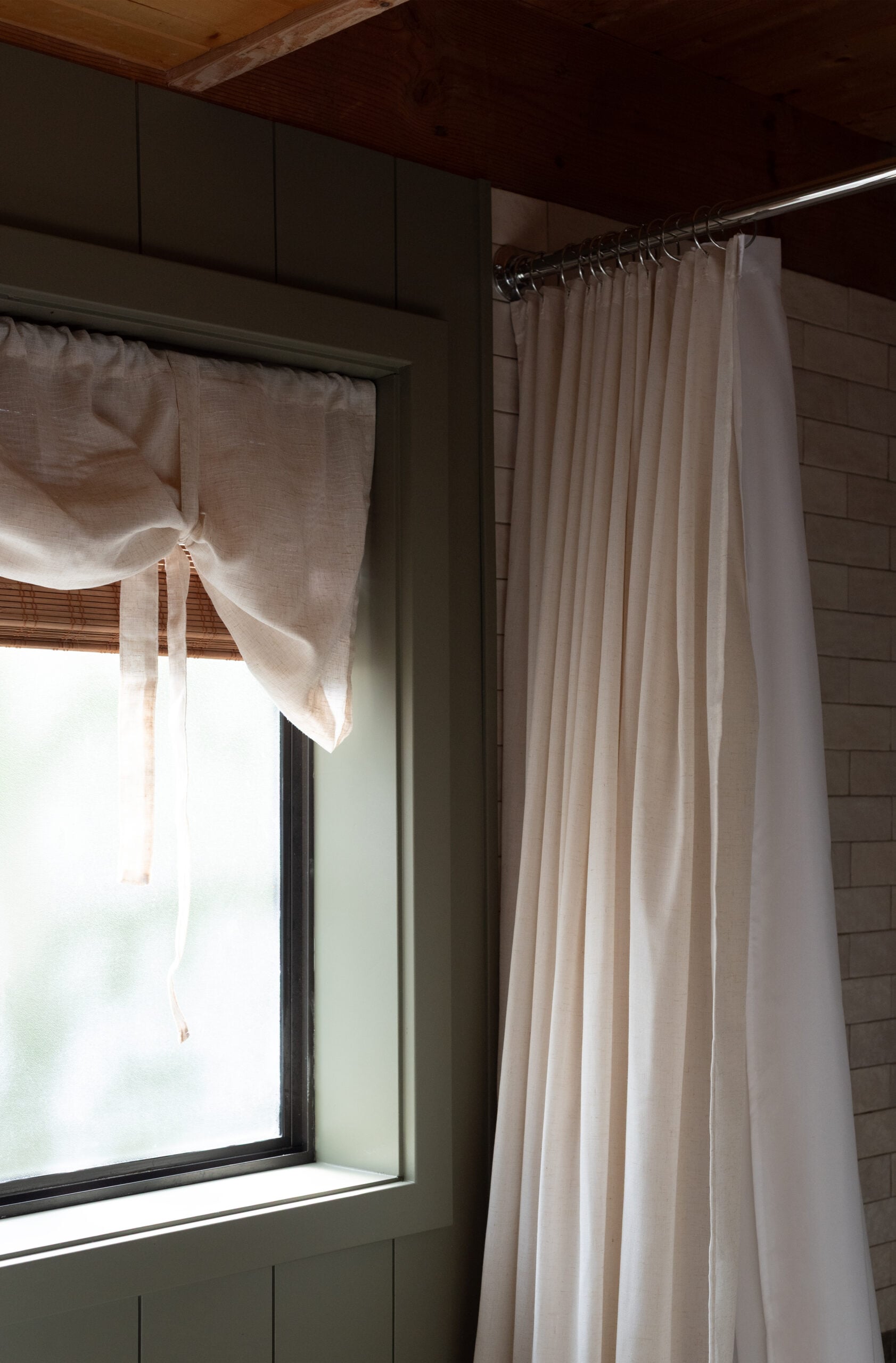 Layered Linen Valence Over Woven Roman Shade in Cabin Bathroom