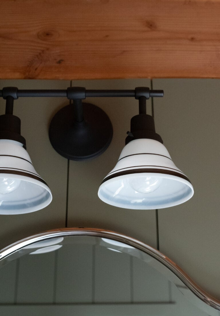 Sconce from Rejuvenation with Striped Milk Glass Shades in Cabin Bathroom