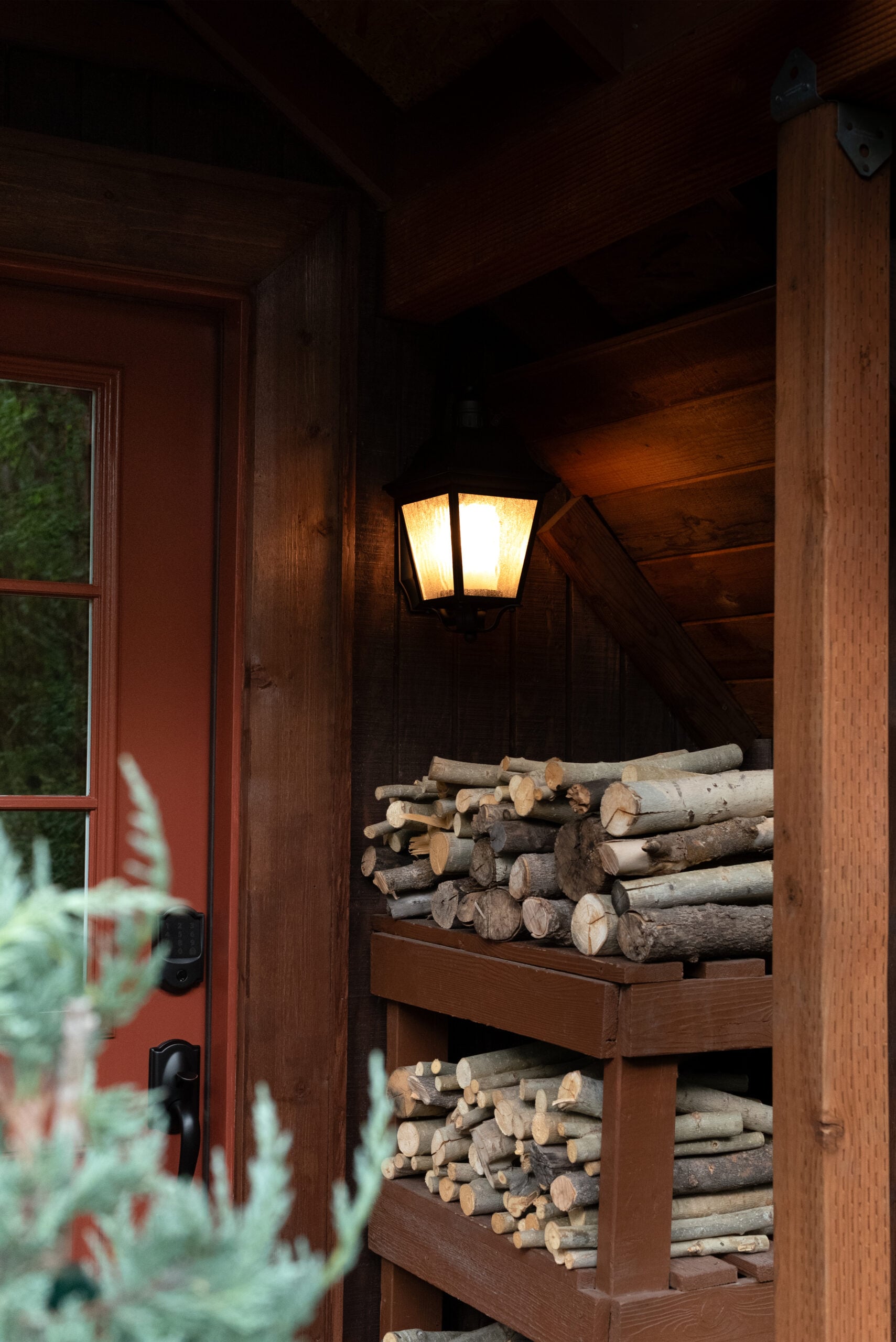Stacked Wood Outside Cabin Front Door Under Porch Light