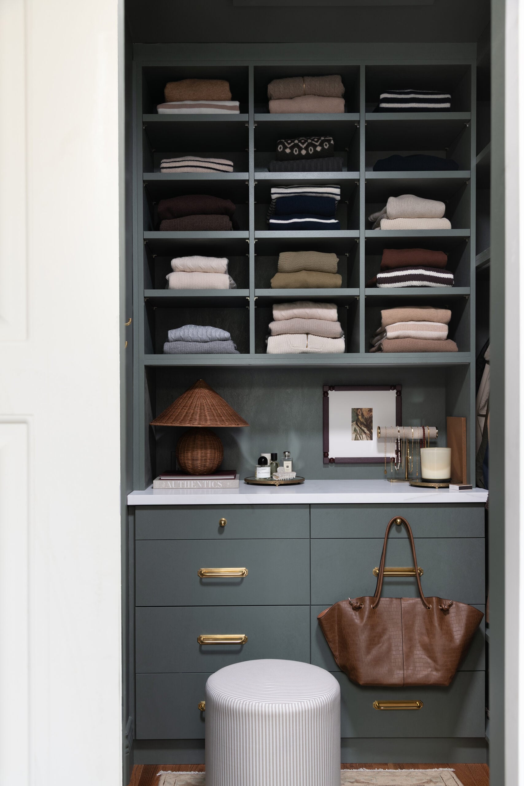 Dark Green Teal Walk In Closet with Marble Countertop and Wall of Sweaters