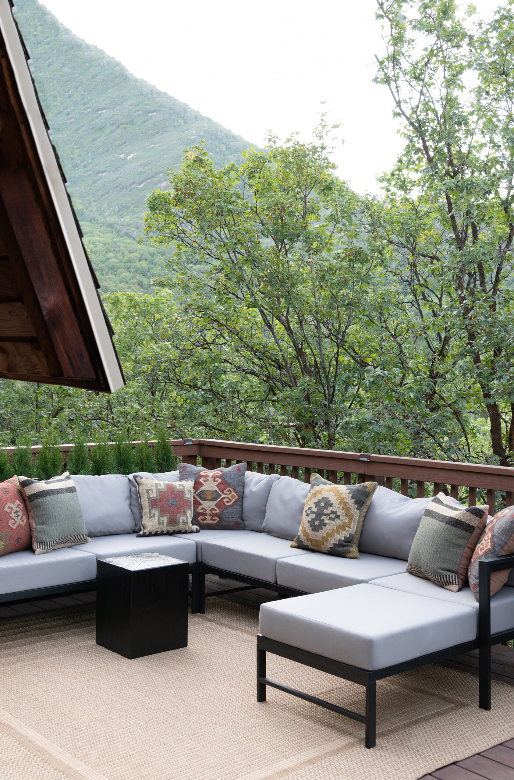 Outdoor Corner Sectional on Cabin Deck with Southwest Pillows and Black Table