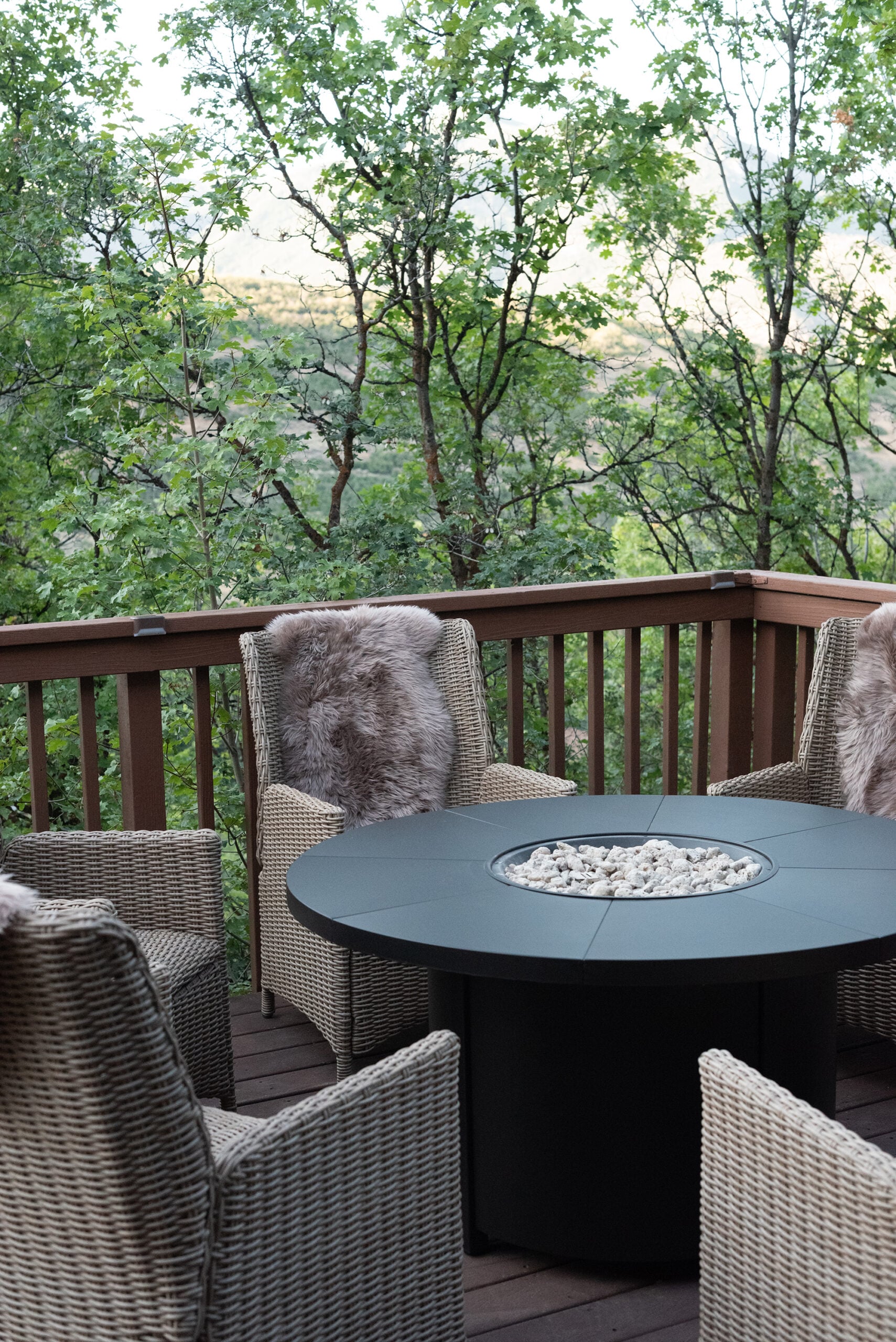 Black Fire Table with Neutral Stones in Center and Woven Chairs
