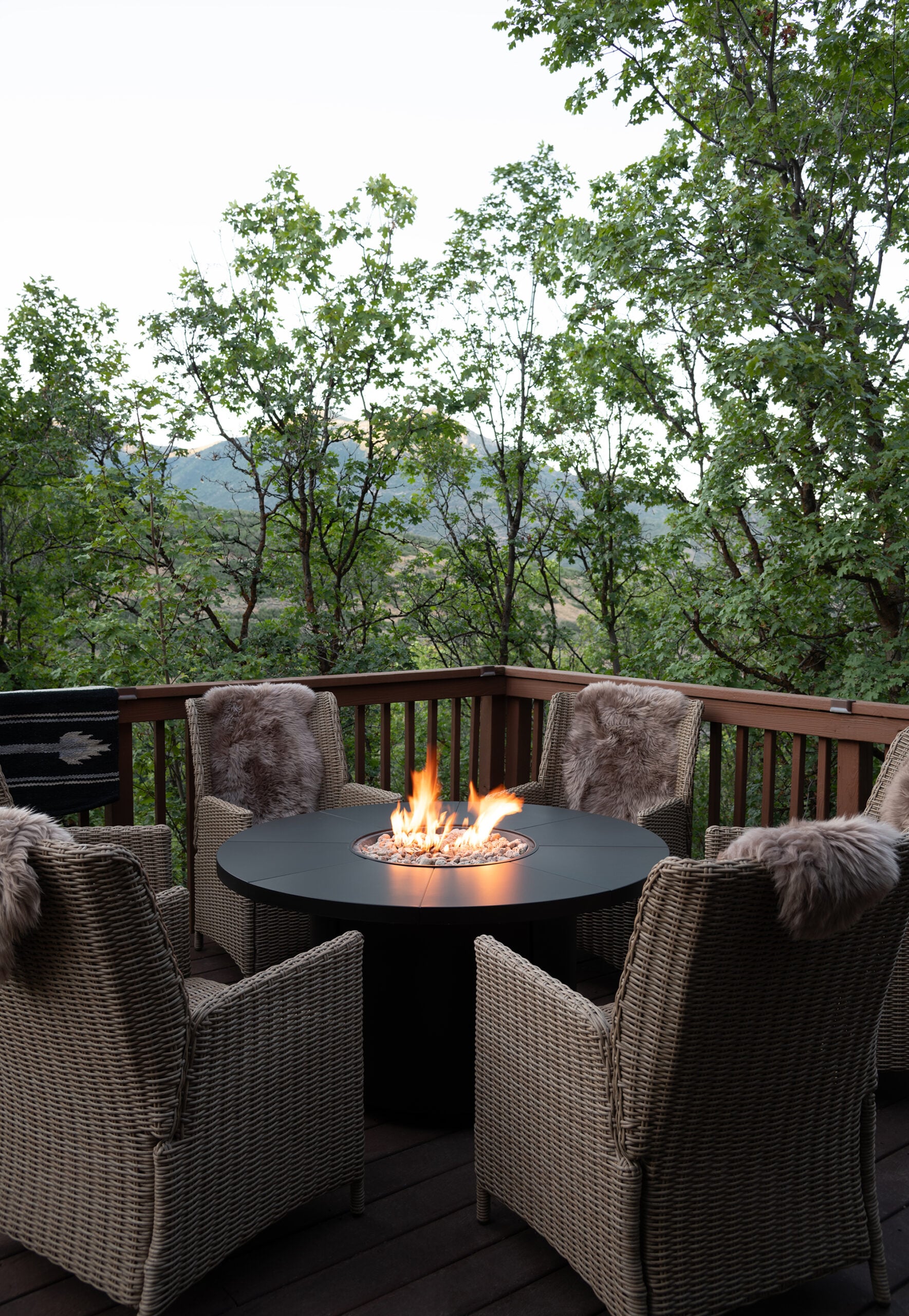 Six Woven Outdoor Chairs Around Black Fire Table
