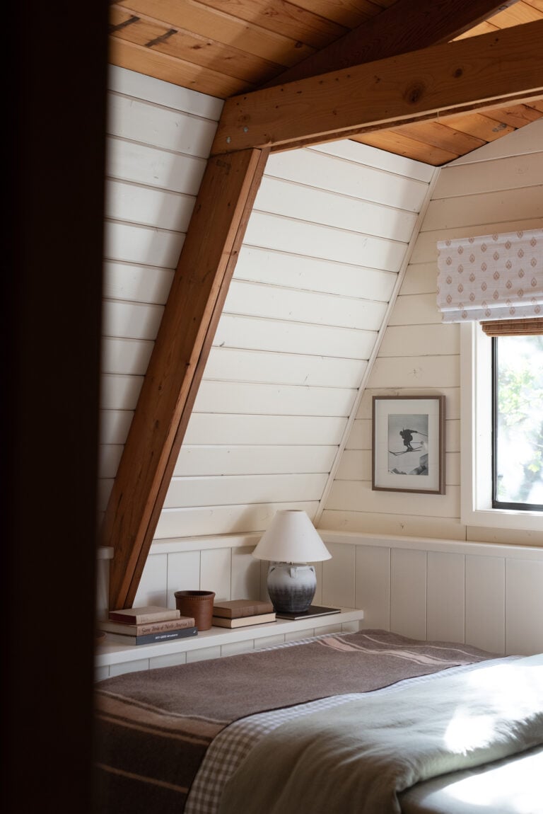 Custom Bed in Cabin Bedroom with Vintage Ski Art and Large Beams