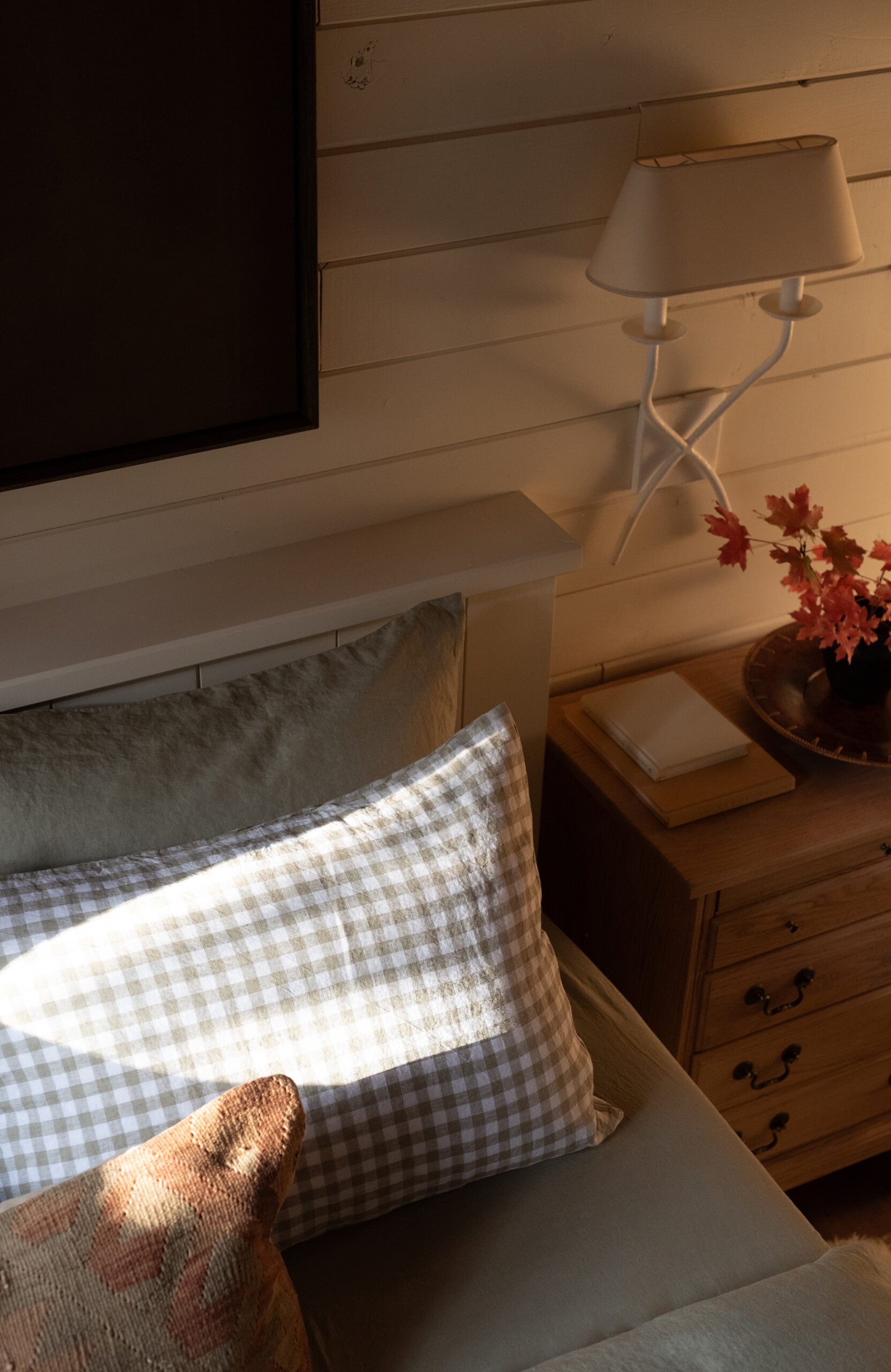 Soft Linen Bedding in Cabin Bedroom with Bedside Sconce and Vintage Nightstand